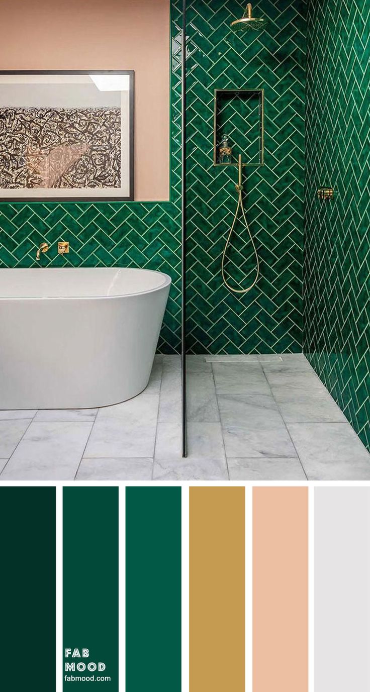 a bathroom with green tiles and gold accents on the walls, along with a white bathtub