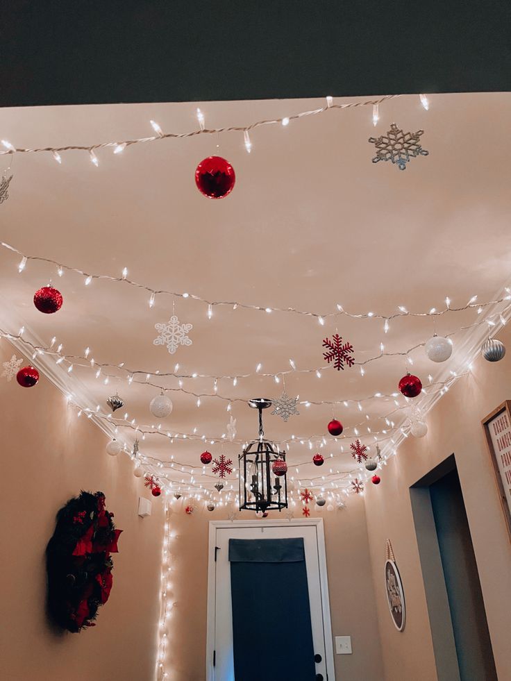 a hallway decorated for christmas with lights and snowflakes on the ceiling above it