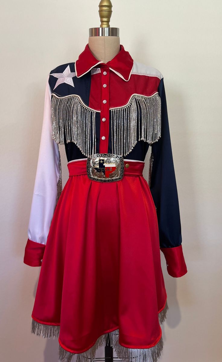 You won't be lonely for long in the lone star dress! Made to order a line pearl snap dress features rhinestone fringe and silver metallic fringe. Dress is made out of a high quality satin and Texas flags. Dress comes complete with a matching satin belt with oversized Texas belt buckle. Red Cowgirl Dress, 70s Texas Fashion, Cowgirls Costume, Rodeo Dresses, Royalty Outfits, Long Closet, Texas Belt Buckle, Texas Dress, Usa Costume