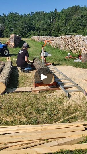 a man sitting on top of a pile of wood