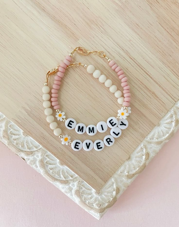 two bracelets with words on them and flowers