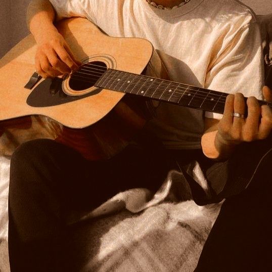 a young man is playing an acoustic guitar