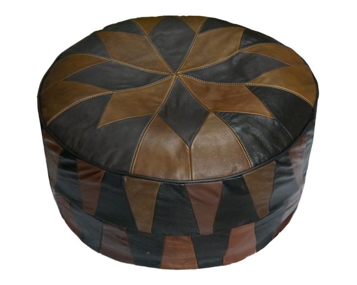 a brown and black leather ottoman sitting on top of a white floor