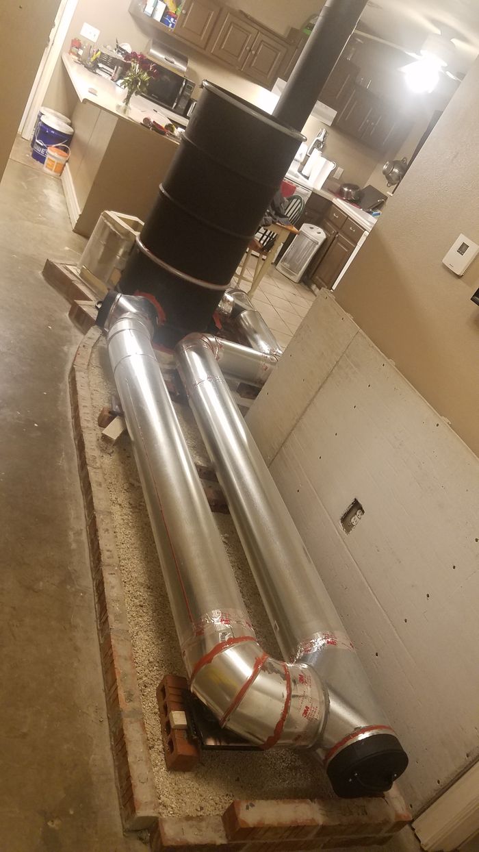 a large metal object sitting on top of a wooden pallet in a kitchen next to a stove