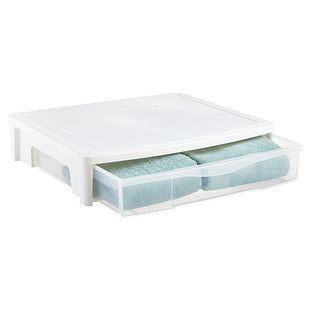 an open plastic storage box with two folded towels in the bottom and one folded towel on top