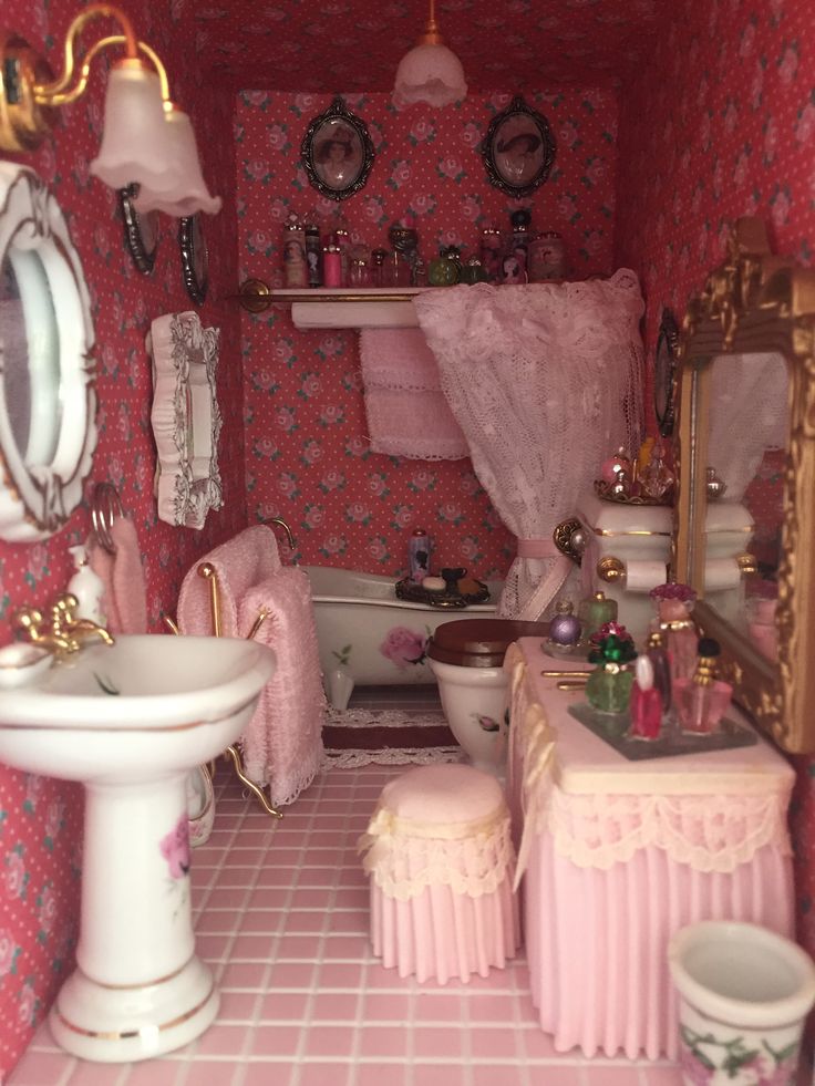 a doll house bathroom with pink walls and flooring, sink, mirror, toilet, and bathtub