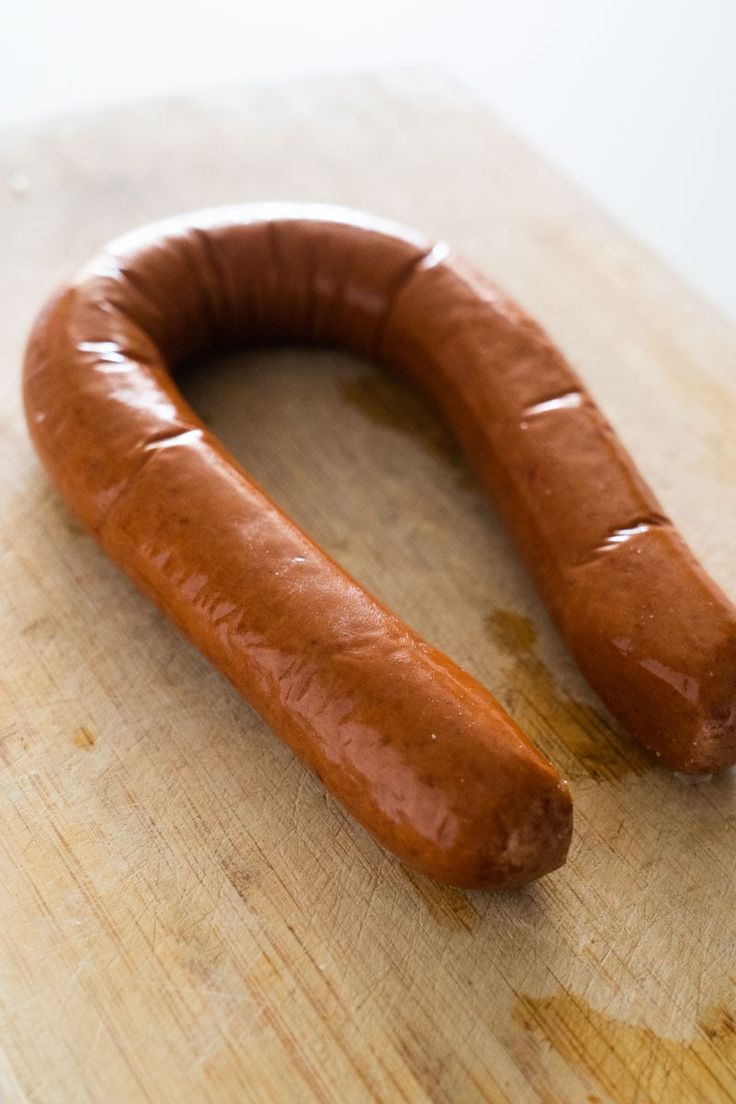 a long hot dog on a wooden cutting board