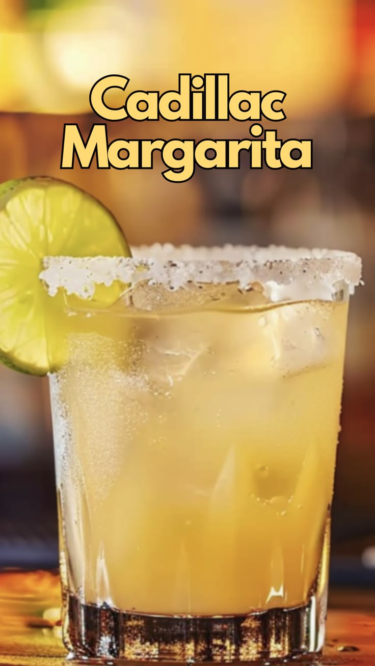 a close up of a drink in a glass with a lime slice on the rim