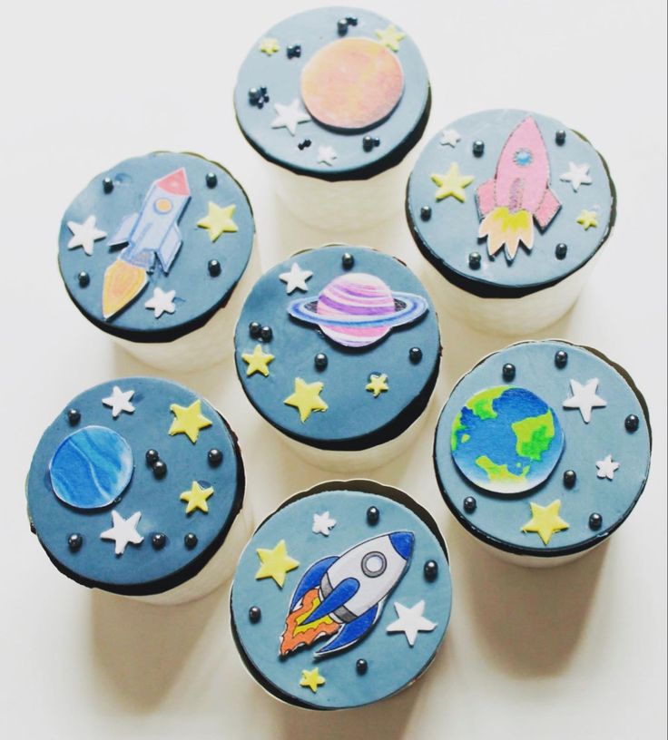 six cupcakes decorated with space themed icing