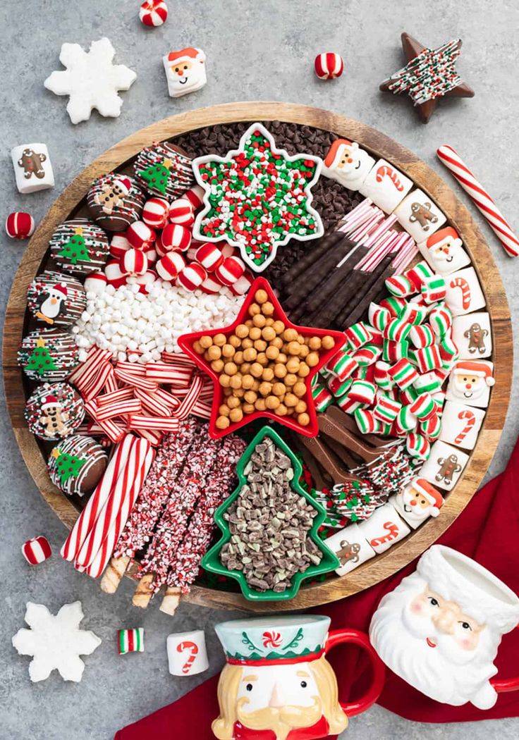 a wooden platter filled with christmas cookies and candy