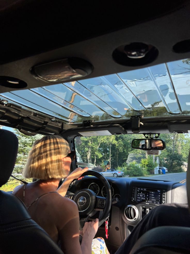 two women sitting in the driver's seat of a car