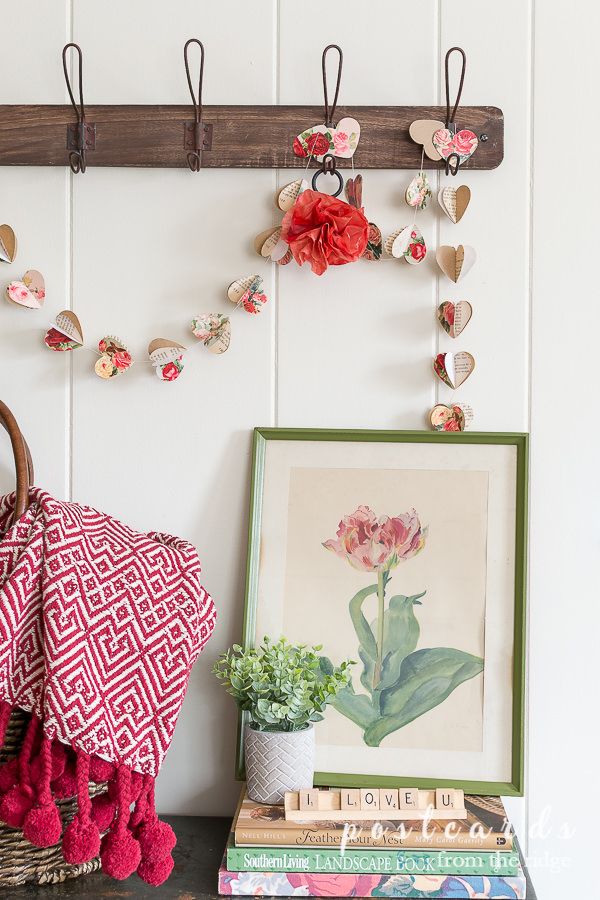 a shelf with flowers and books on it next to a potted plant in a basket