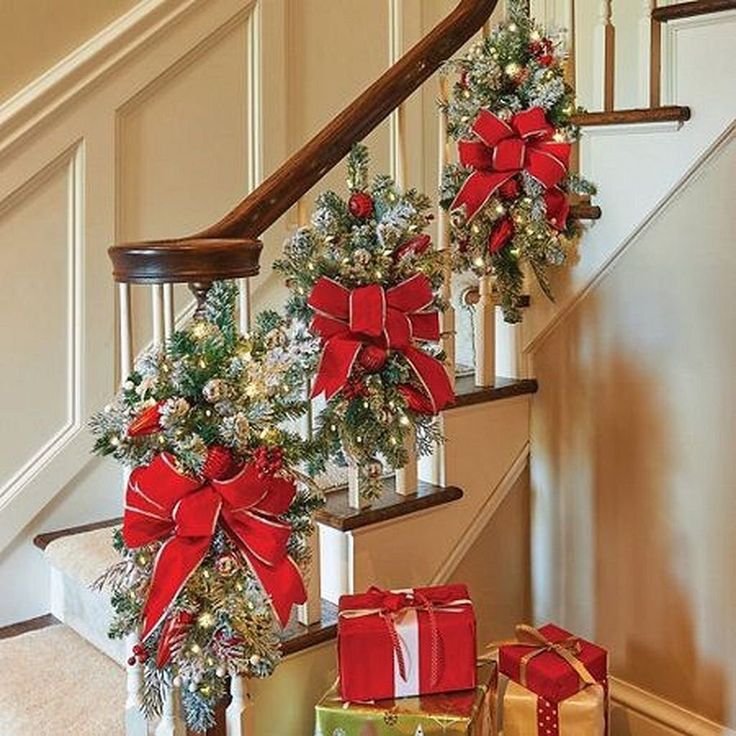 christmas decorations on the banisters and stairs with presents under them in red bows