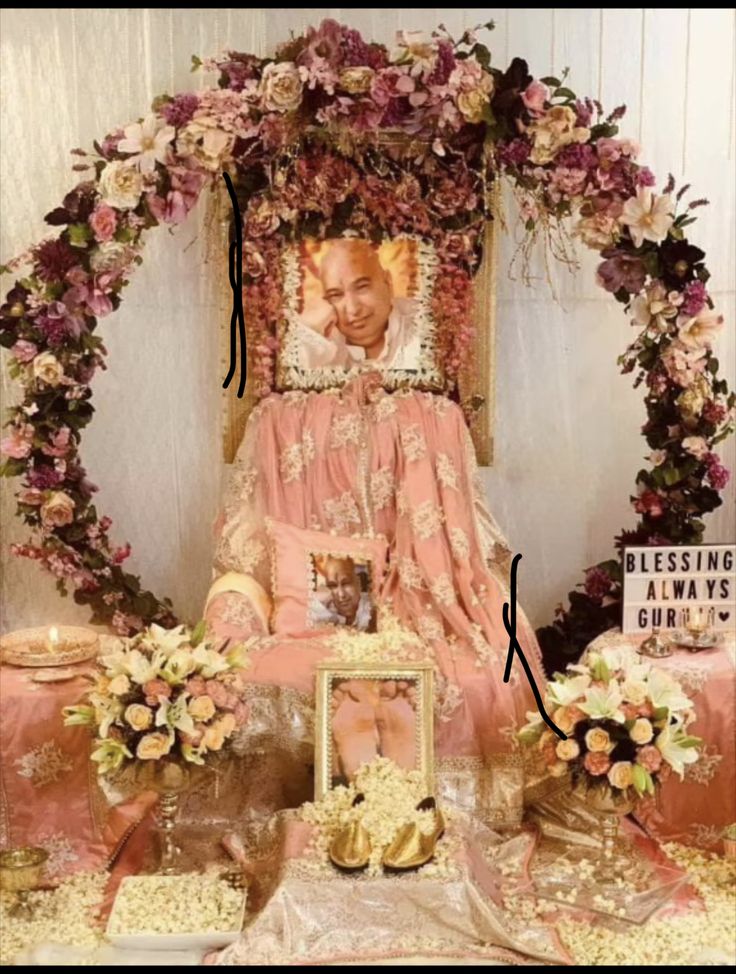 an elaborately decorated chair with flowers around it and a photo on the wall behind it