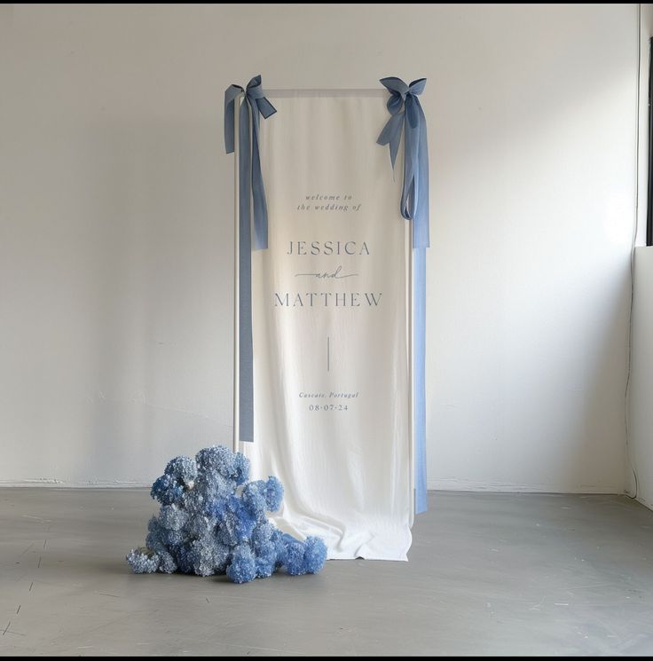 a blue teddy bear sitting in front of a white backdrop