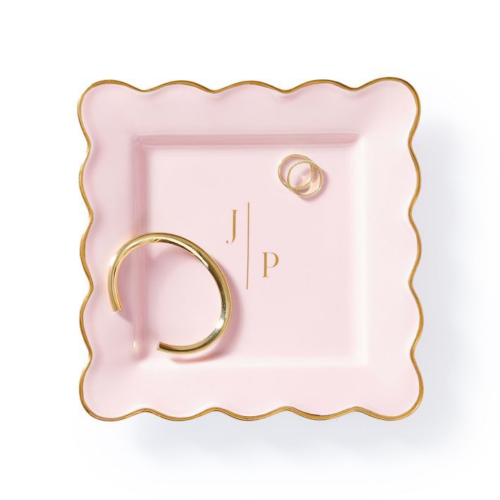 a pink and gold plate with a ring on it