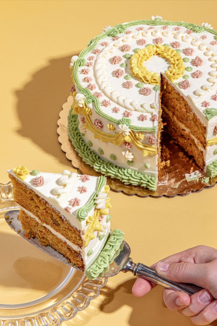 a person cutting a piece of cake with a knife