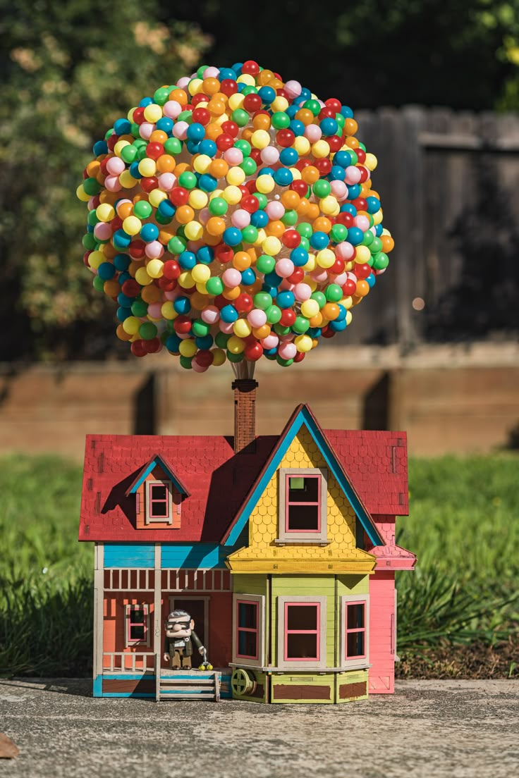 a toy house with a tree made out of balloons