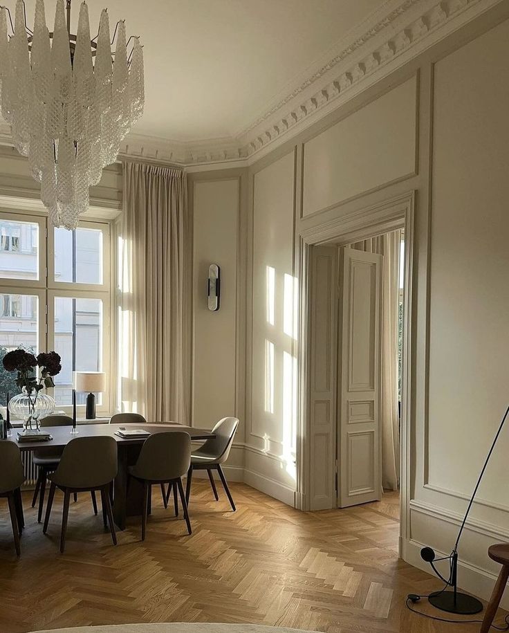 an elegant dining room with chandelier and wooden floors