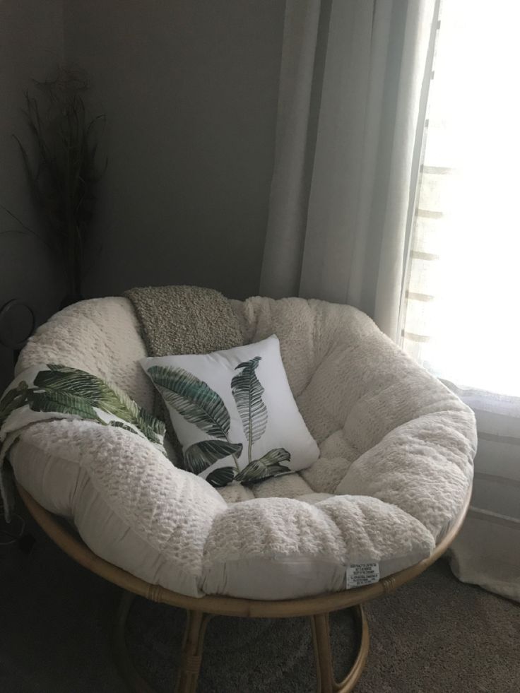 a chair with a pillow on it in front of a window