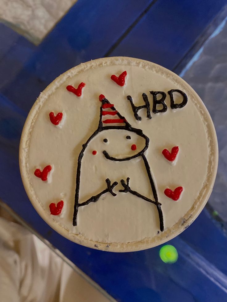 a decorated cake with the words hbd and a dog wearing a party hat