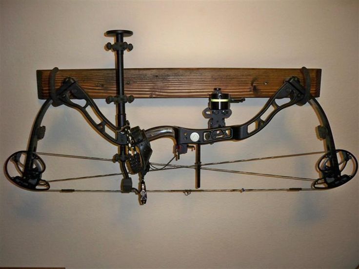 a wall mounted bow and arrow rack with two arrows attached to the back of it