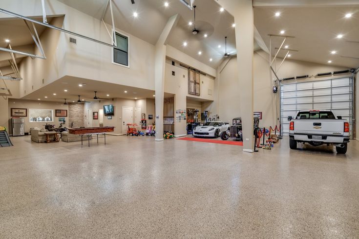 the inside of a large garage with two cars parked in it's center area