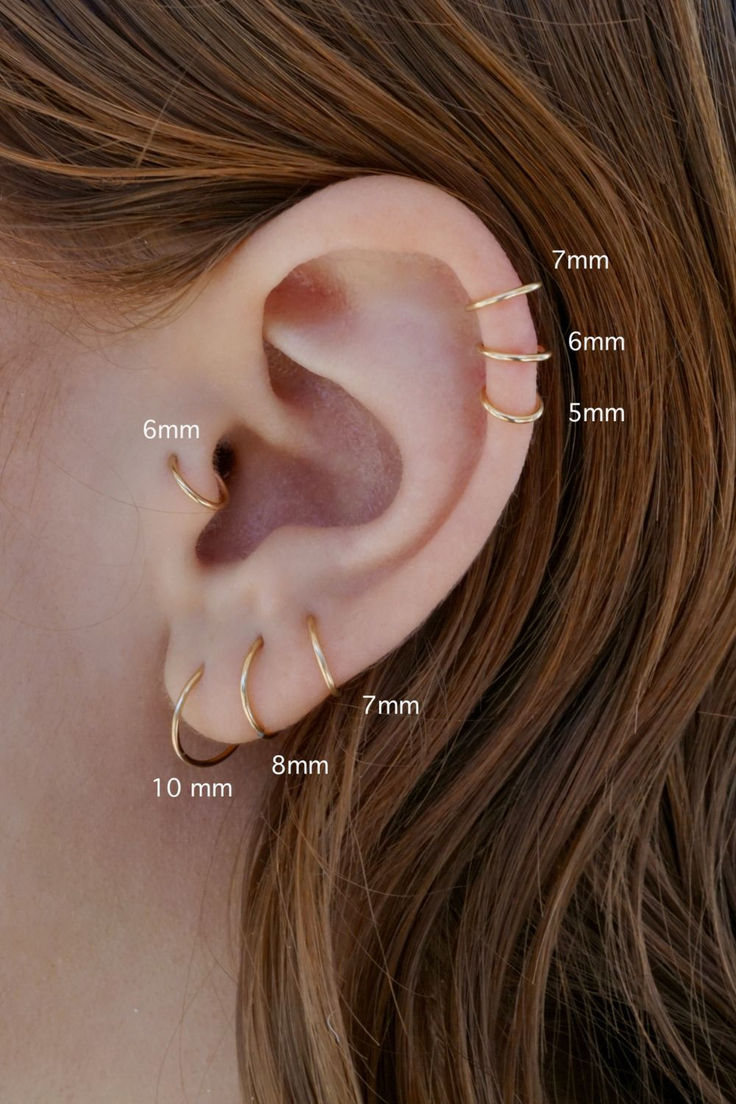 an ear with three different types of piercings on the top and bottom of it