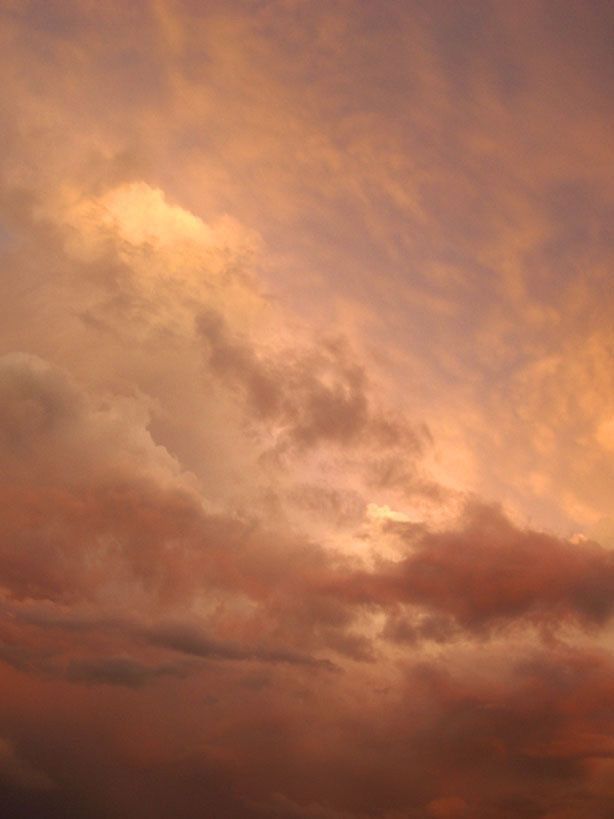 an airplane is flying in the sky at sunset or dawn with some clouds behind it