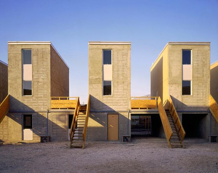 the building is made out of concrete and has stairs leading up to two levels with windows on each side