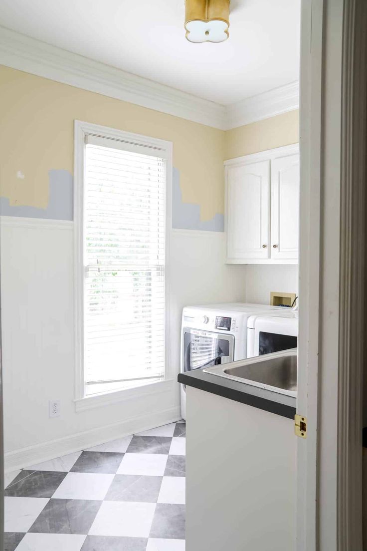 an empty kitchen with white cabinets and black counter tops in front of a checkered floor