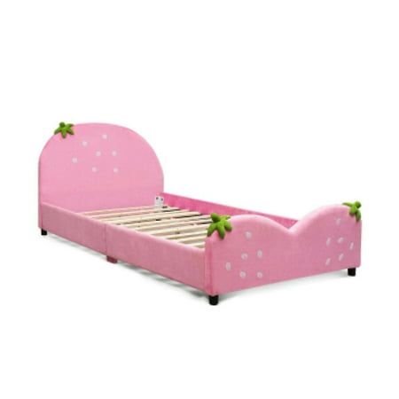 a pink bed with white polka dots and green leaves on the headboard is shown