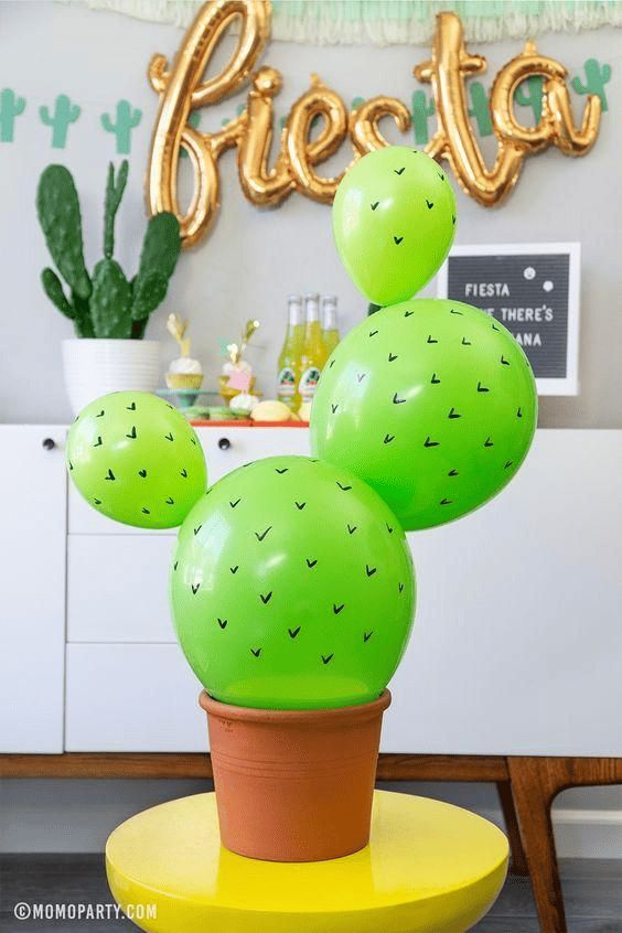 a green cactus plant sitting on top of a yellow table