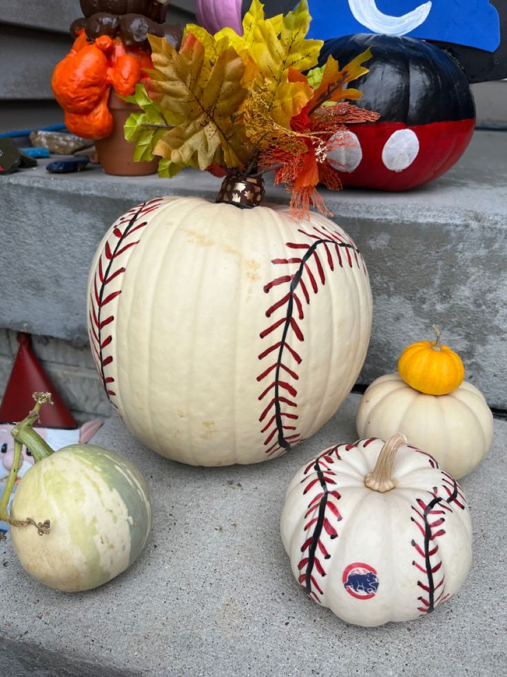 baseball pumpkins and gourds are sitting on the steps next to each other