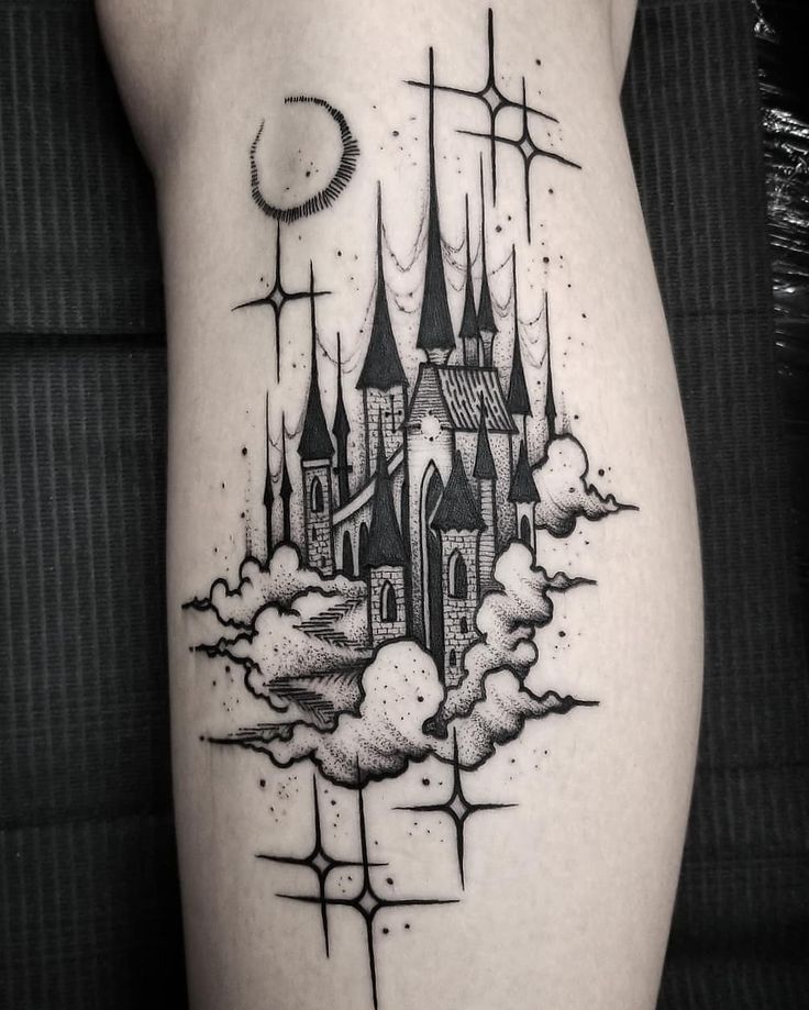 a black and white photo of a castle tattoo on the right side of the leg