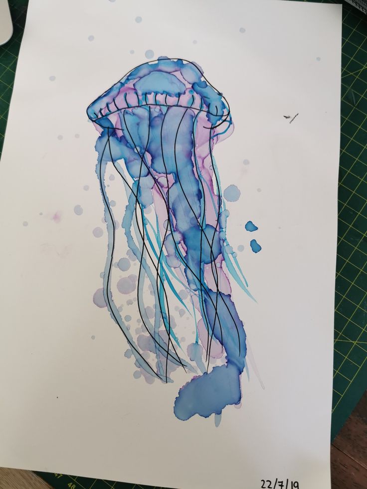 a watercolor drawing of a jellyfish in blue, pink and purple ink on white paper