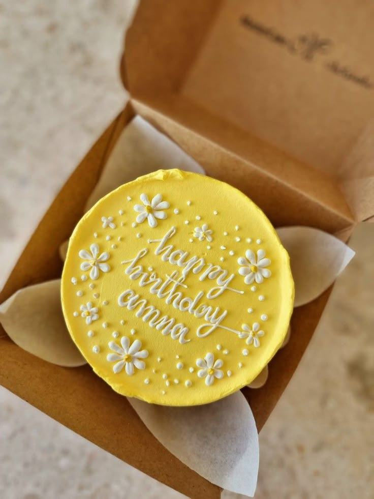 a yellow cookie sitting inside of a brown box