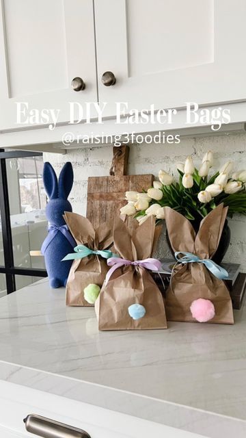 three bags with bunny ears on them sitting on a kitchen counter next to some flowers