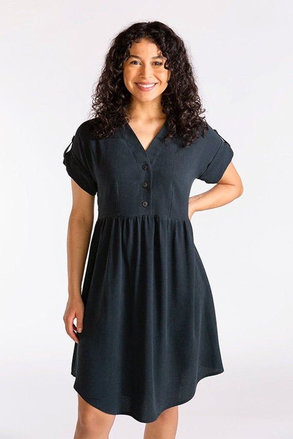 a woman in a black dress posing for the camera with her hands on her hips