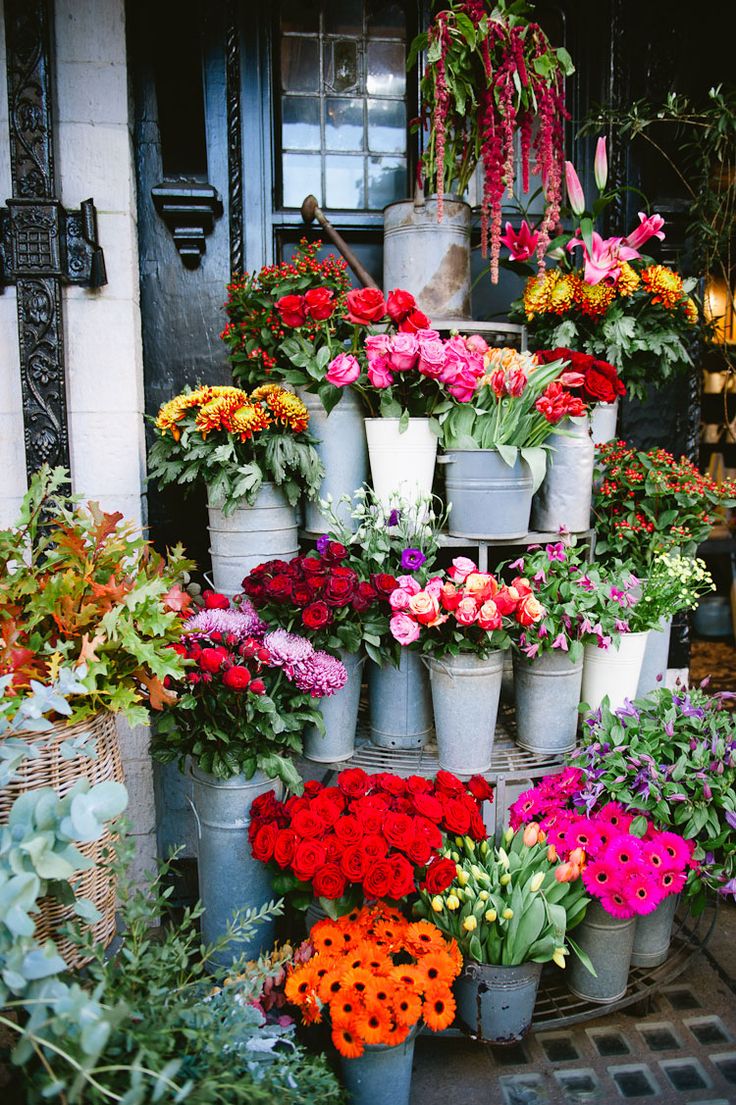 many potted flowers are stacked on top of each other