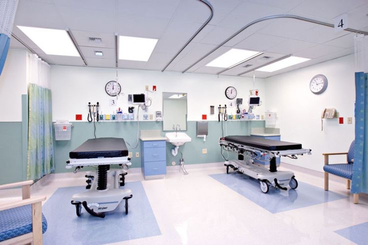 an empty hospital room with medical equipment in it's walls and lights on the ceiling