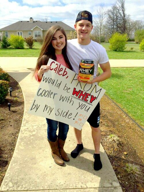 a man and woman standing on a sidewalk holding signs that read cake, i would't be whey