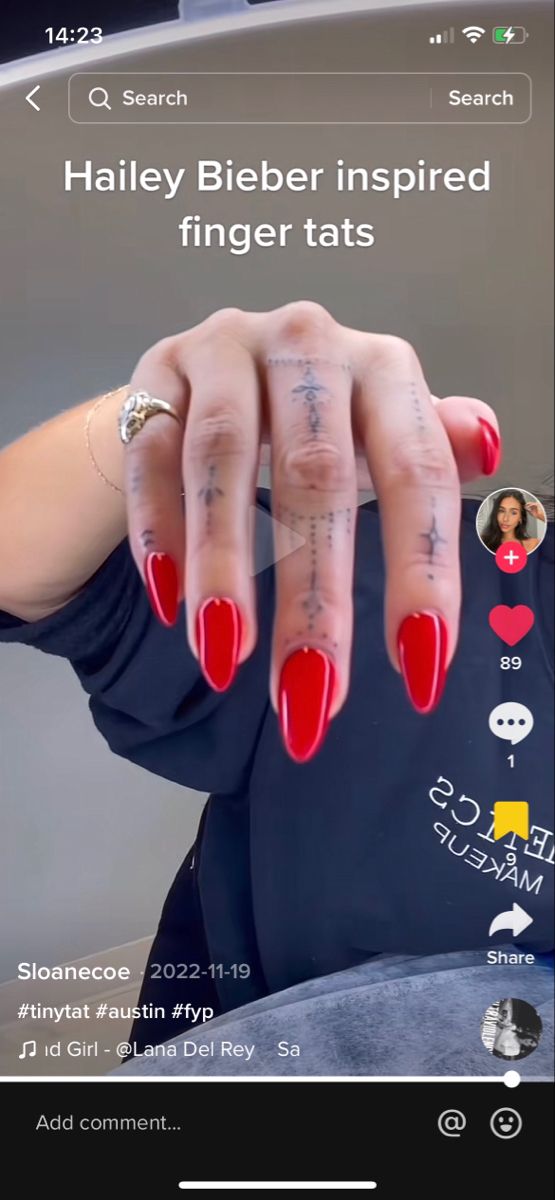 a woman's hand with red nails and tattoos on her fingers is shown in an instagram