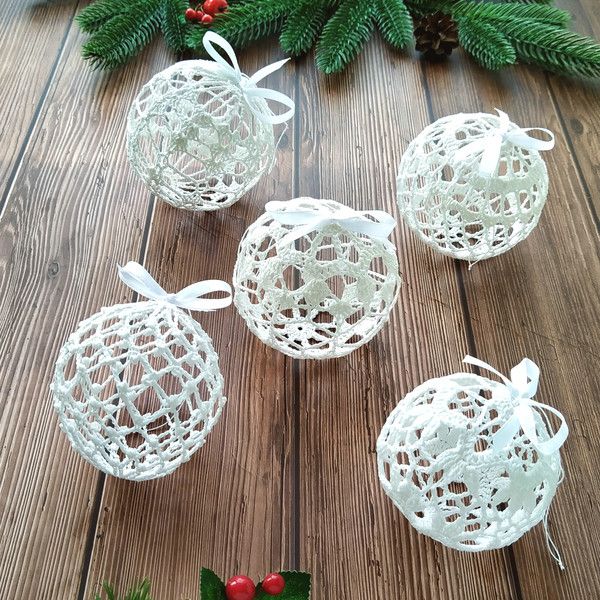 four white christmas balls on a wooden table