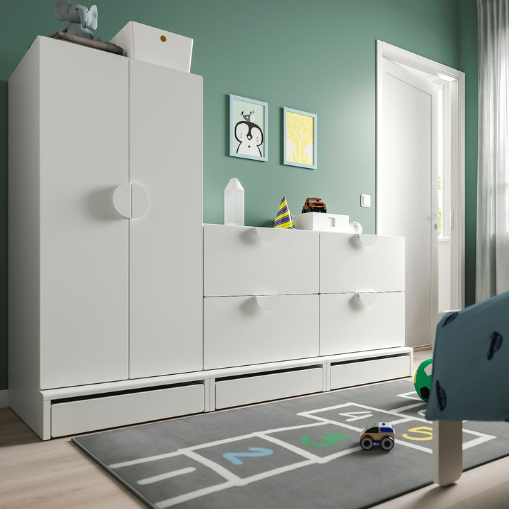 a child's bedroom with blue and white furniture in the room, including a toy car