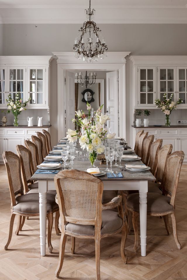 the dining room table is set with place settings for eight people and flowers in vases