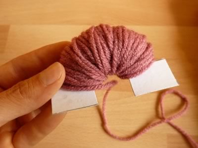 a ball of pink yarn being held by a hand