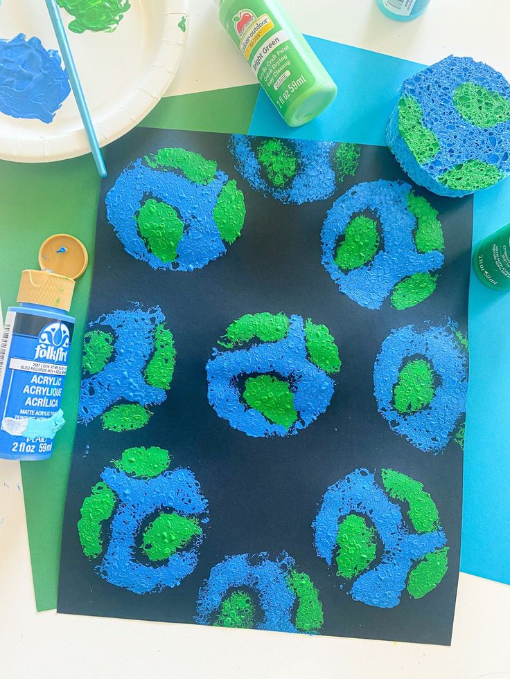 blue and green cupcakes are sitting on a table next to some other items