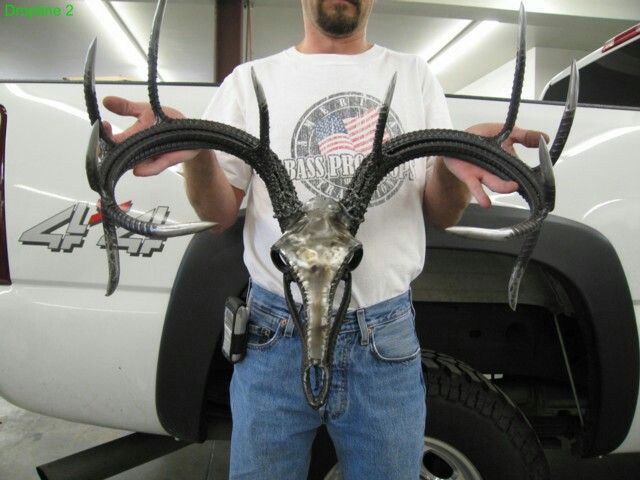 a man standing next to a white truck with horns on it