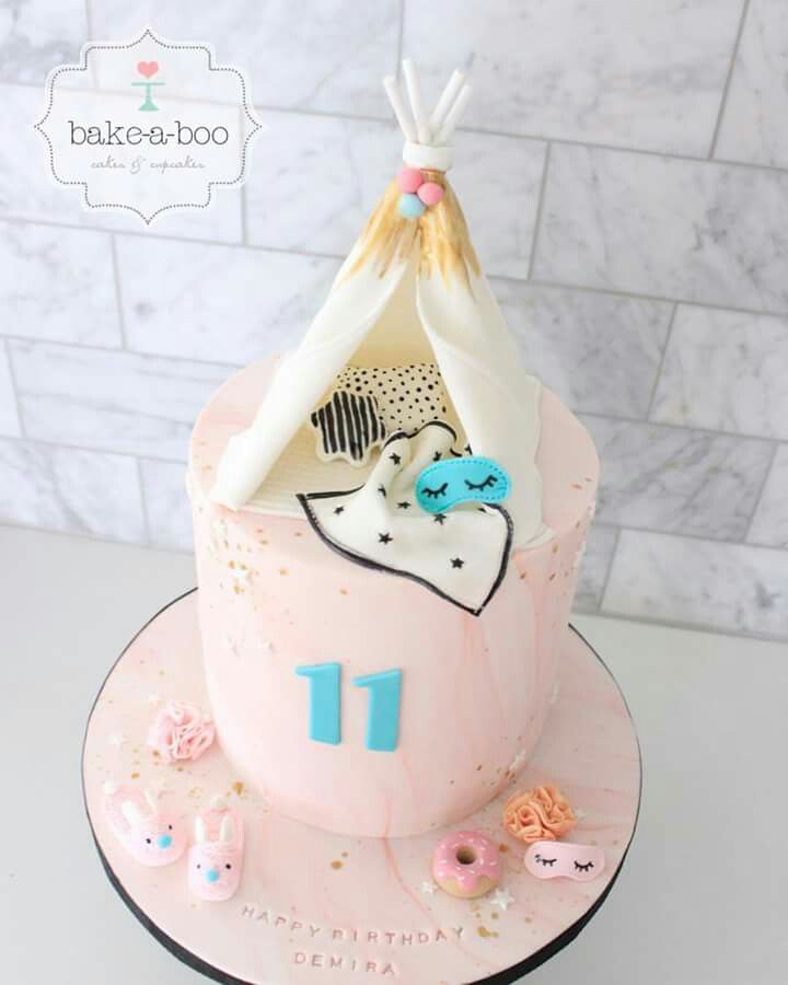 a pink birthday cake with a teepee tent on top